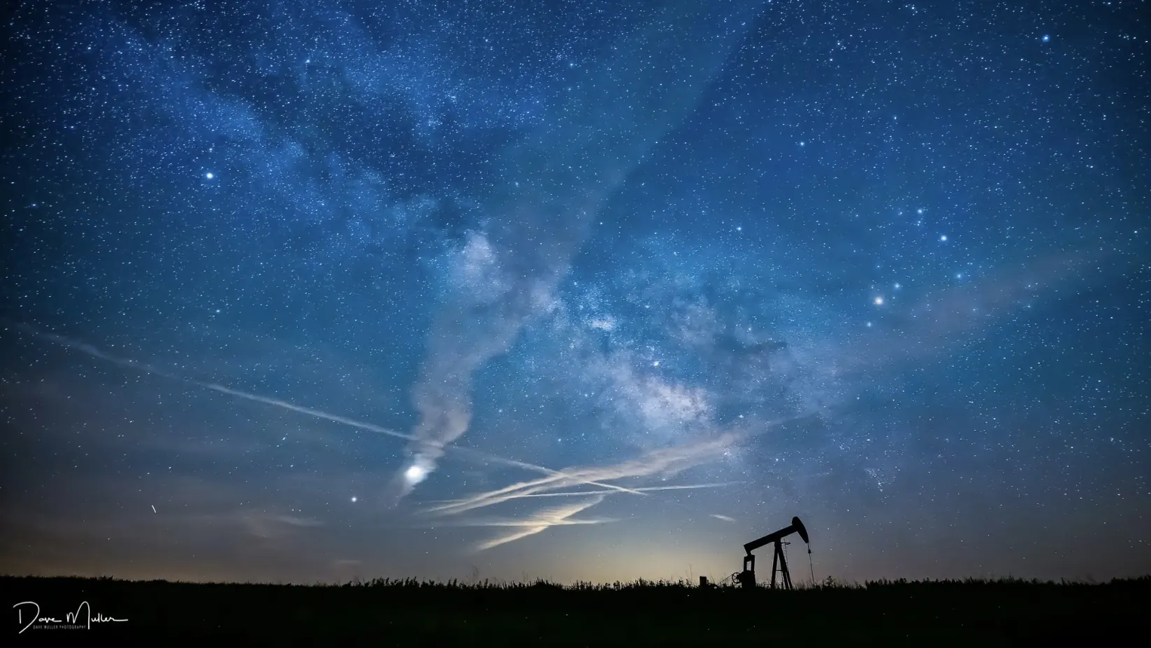 Pumpjack beneath a star-filled prairie sky